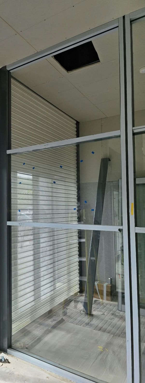 Aluminium glazed screen fitted alongside a roller shutter