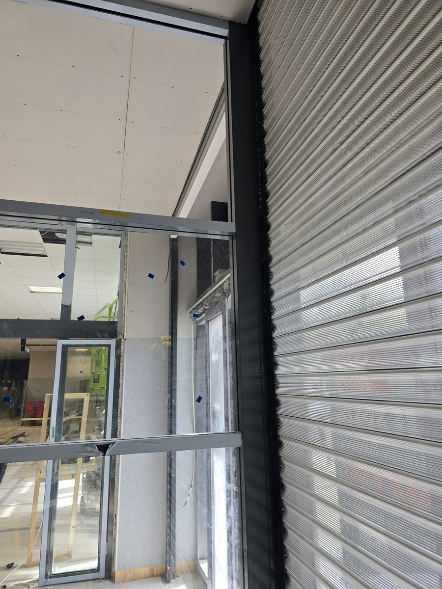 Close-up of anthracite aluminium framing meeting a roller shutter